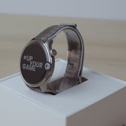 Amazfit Balance cinzento com ecrã AMOLED redondo 1,5, caixa metálica prateada e bracelete têxtil cinza com fecho ajustável, apresentado em embalagem branca