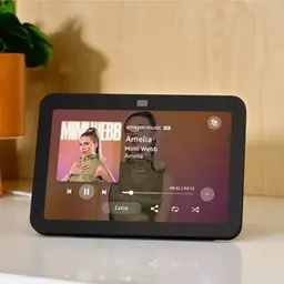 Amazon Echo Show 8 3ª generación gris antracita con pantalla táctil mostrando música, biseles negros, cámara superior centrada y soporte de sobremesa