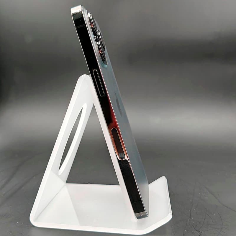 iPhone 13 Pro 128Go Graphite Renowed État Premium sur support blanc, tranche latérale plate en acier, boutons visibles, module photo pro épais