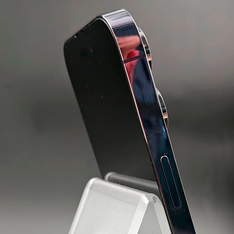 iPhone 14 Pro Max morado oscuro, borde lateral pulido con brillo, doble cámara trasera sobresaliente, acabado impecable “Renovado – Excelente”.