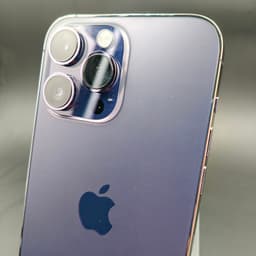 Módulo triple de cámaras del iPhone 14 Pro Max morado oscuro, lentes grandes con aro metálico y acabado brillante; cuerpo de vidrio pulido, estado excelente.