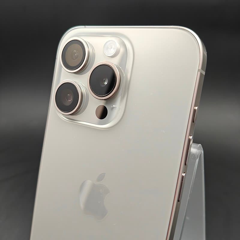 iPhone 15 Pro 5G em titânio natural, módulo triplo de câmeras com bordas metálicas, flash LED, acabamento fosco claro e laterais retas em excelente estado