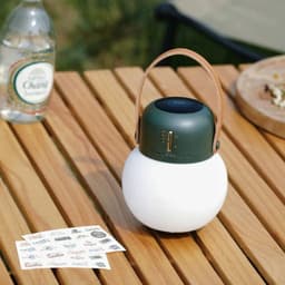 Luz de camping al aire libre con Altavoz Bluetooth Verde Foto real sobre una mesa