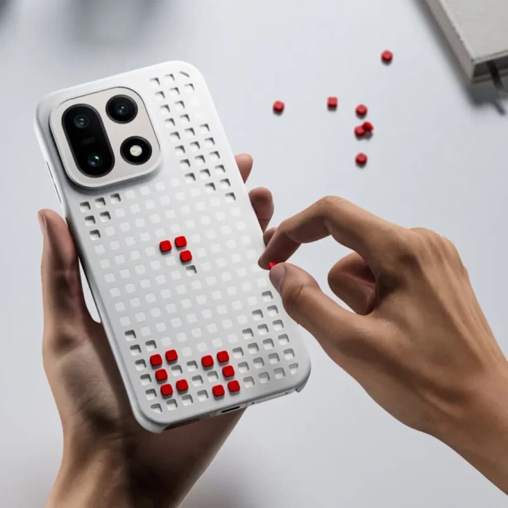 Capa magnética OnePlus 15 Hole-pattern cinzento com grelha quadrada e pequenos pinos vermelhos destacáveis, proteção robusta e design lúdico