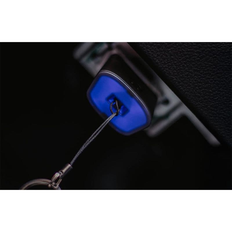 Dongle OBDeleven 3 bleu connecté au port OBD, petite prise carrée avec LED bleue et câble porte-clés, conçu pour diagnostic automobile rapide.