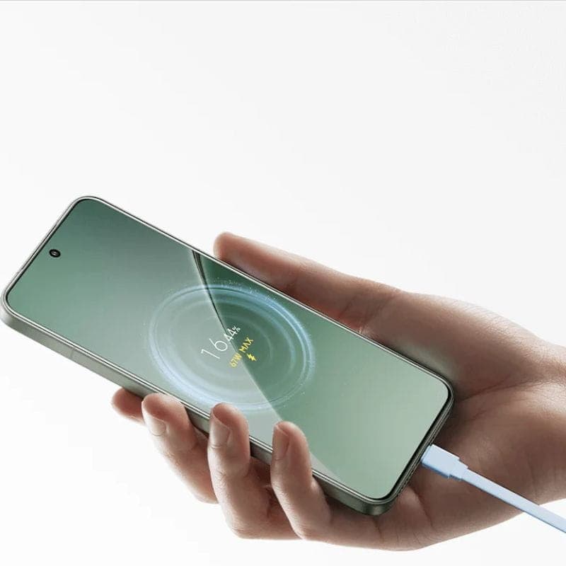 Mano sosteniendo smartphone cargándose con cable azul, mostrando animación de carga y porcentaje 16% sobre pantalla verde, borde metálico y cámara frontal