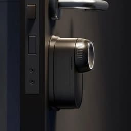 Fechadura inteligente SwitchBot Ultra em preto fosco, cilindro rotativo iluminado e corpo compacto fixado à porta, design moderno e discreto para controlo