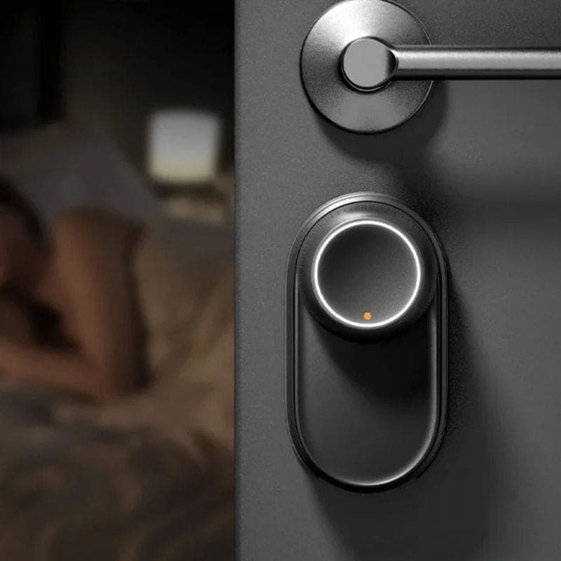Fecho inteligente SwitchBot Ultra 3 em 1 em porta cinza, corpo preto fosco com anel LED circular e ponto laranja, design minimalista para controlo de acesso