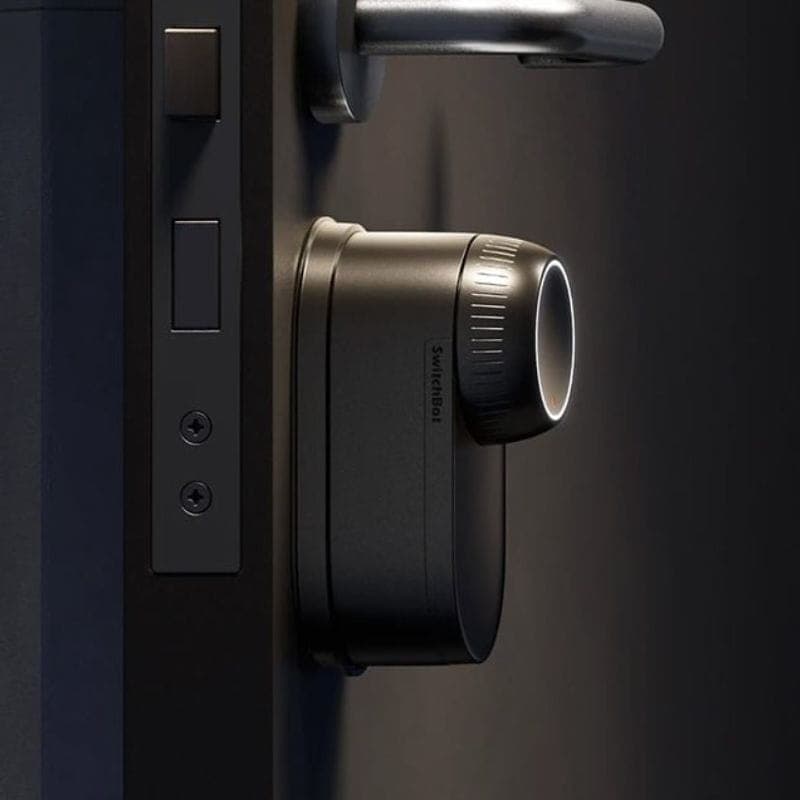Fechadura inteligente SwitchBot Lock Ultra Prateado montada na porta, corpo metálico cinza, botão giratório iluminado e design compacto e moderno