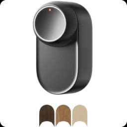 Fecho inteligente SwitchBot Lock Ultra Preto com corpo preto fosco, botão giratório metálico com LED laranja e adaptadores em três acabamentos de madeira