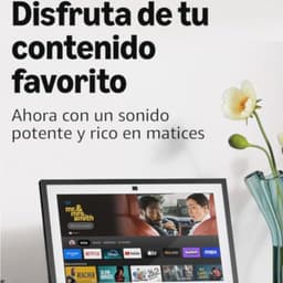 Pantalla inteligente de 15.6 pulgadas FullHD con bisel negro, interfaz Fire TV, iconos de apps en la parte inferior y cámara superior; incluye mando por voz