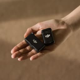 DJI Mic 2 1 TX + 1 RX présentés dans une main: boîtiers compacts noirs avec logo DJI, émetteur et récepteur portables pour enregistrement audio sans fil