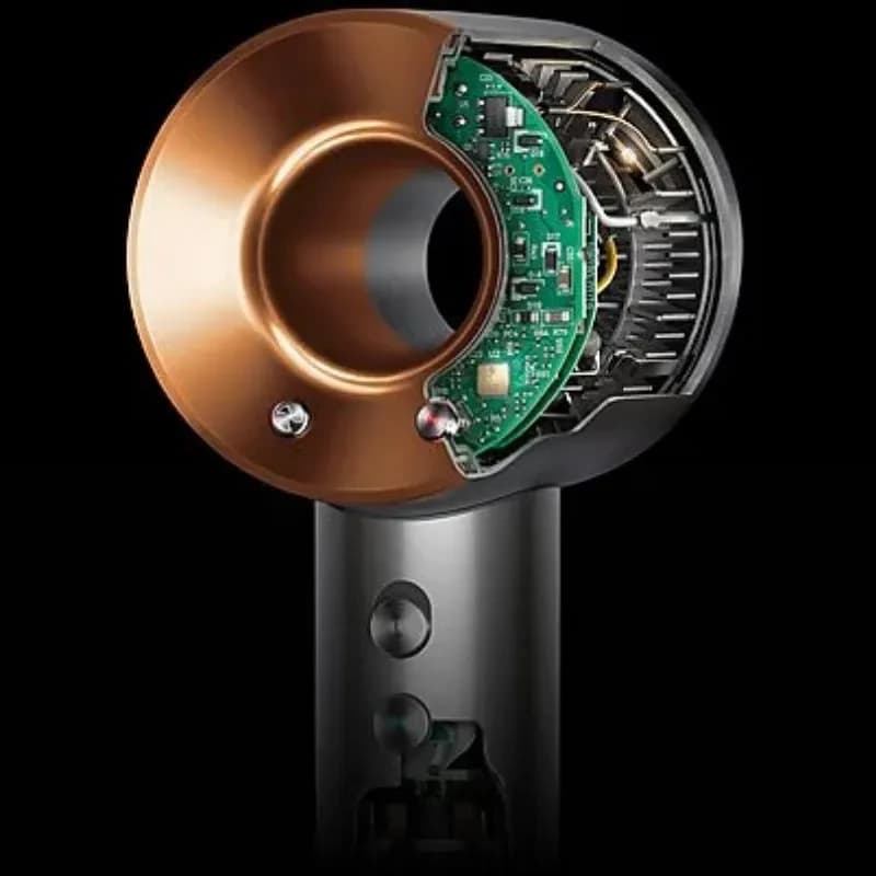 Coupe du Dyson Supersonic HD07 Nickel/Cuivre montrant turbine interne et carte électronique, finition métallique premium, design circulaire sans pales