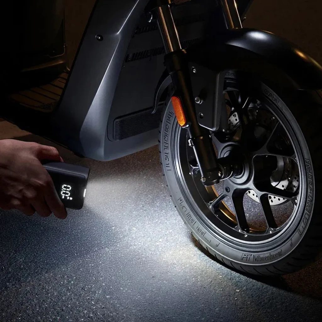 Compresor portátil negro Mijia con pantalla LED que muestra presión en BAR, botones circulares, manguera lateral con válvula metálica y linterna integrada - Ítem3