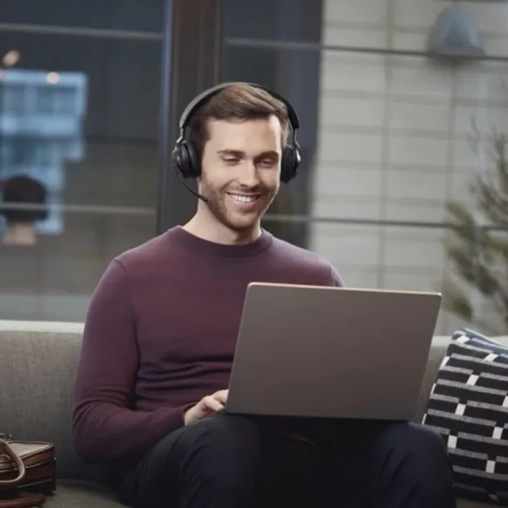 Homme portant le casque Jabra Evolve2 65 Stereo avec micro rabattable, coussinets rembourrés et arceau noir, connecté à un ordinateur portable