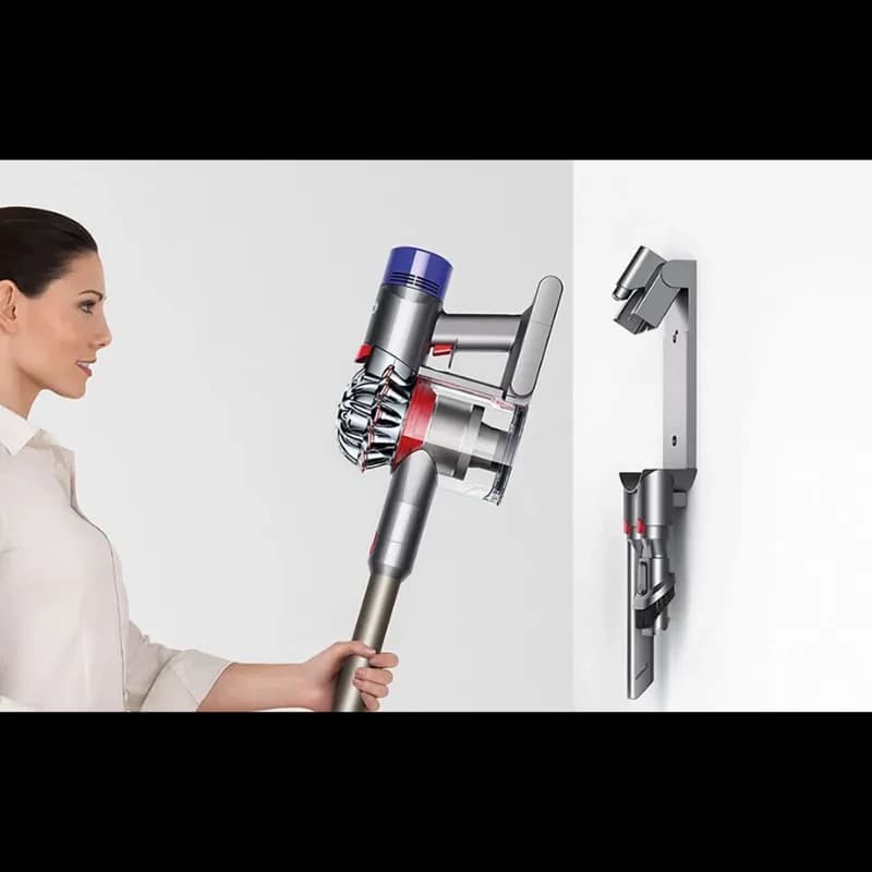 Dyson V8 Cyclone montada en pared con soporte y accesorios; diseño ergonómico, cuerpo plateado con detalles rojos y azules, depósito transparente 0,54 l
