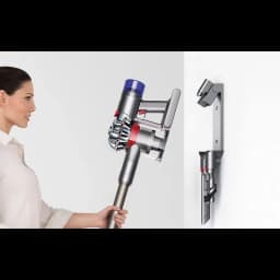 Dyson V8 Cyclone montada en pared con soporte y accesorios; diseño ergonómico, cuerpo plateado con detalles rojos y azules, depósito transparente 0,54 l