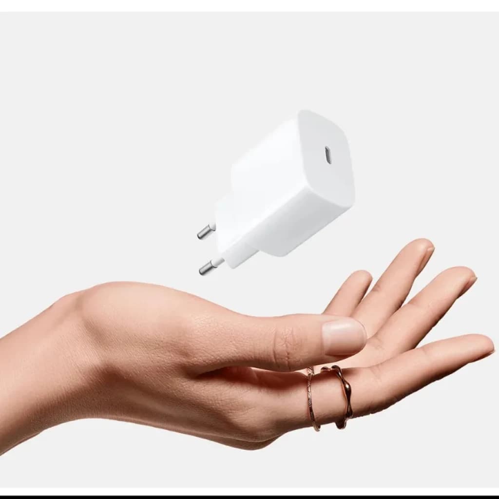 Vista do carregador Xiaomi 20W Fast Charging Power Adapter USB-C na cor branca com uma mão como referência de tamanho
