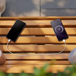 Oppo A6X 128GB negro lila con pantalla de 6.75 pulgadas cargando a otro dispositivo mediante cable, diseño elegante y batería de 6100 mAh visible en pantalla