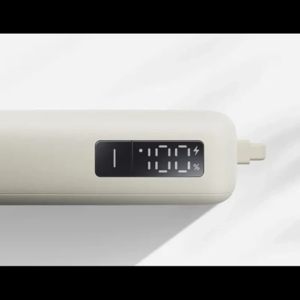 Xiaomi Power Bank 10000mAh bege com cabo integrado, design compacto e ecrã numérico que mostra 100% de carga, saída 67W para carregamento rápido