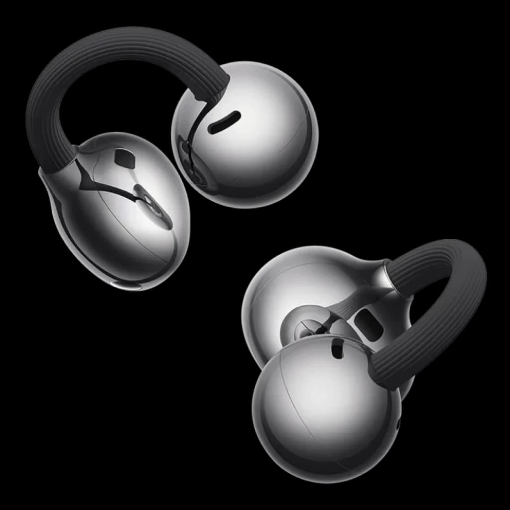 Auriculares Bluetooth con diseño open-ear, ganchos flexibles negro y cápsulas plateadas brillantes, compactos y elegantes