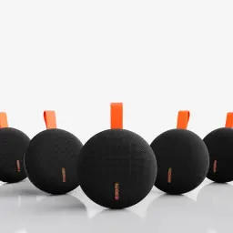 Enceinte portable noire compacte au maillage textile, forme ovale, logo Xiaomi orange, sangle de transport orange, design minimaliste aligné en série