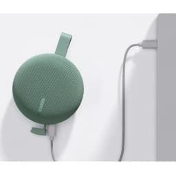 Enceinte portable verte compacte avec sangle, grille textile arrondie, logo Xiaomi discret, câble tressé branché sur port latéral, design minimal IP66