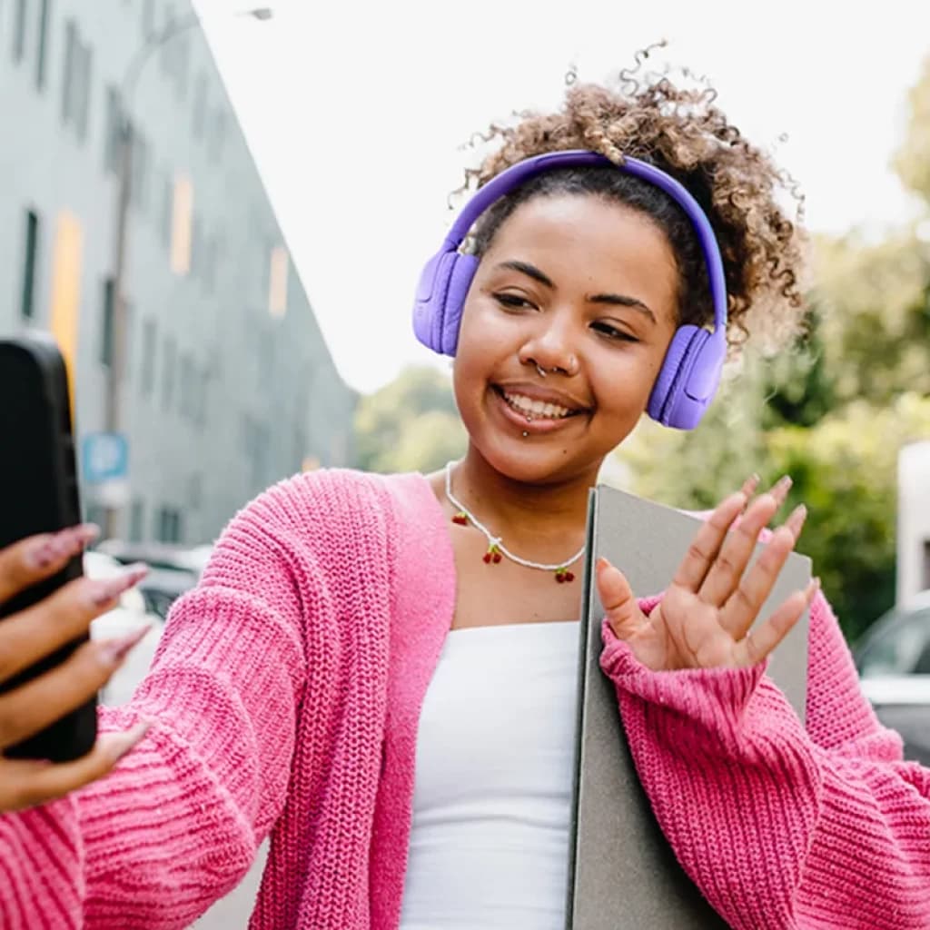 Casque JBL Tune 530BT bleu supra auriculaire au design mat, arceau rembourré et coussinets épais, porté en extérieur par une utilisatrice souriante
