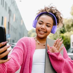 Casque JBL Tune 530BT bleu supra auriculaire au design mat, arceau rembourré et coussinets épais, porté en extérieur par une utilisatrice souriante