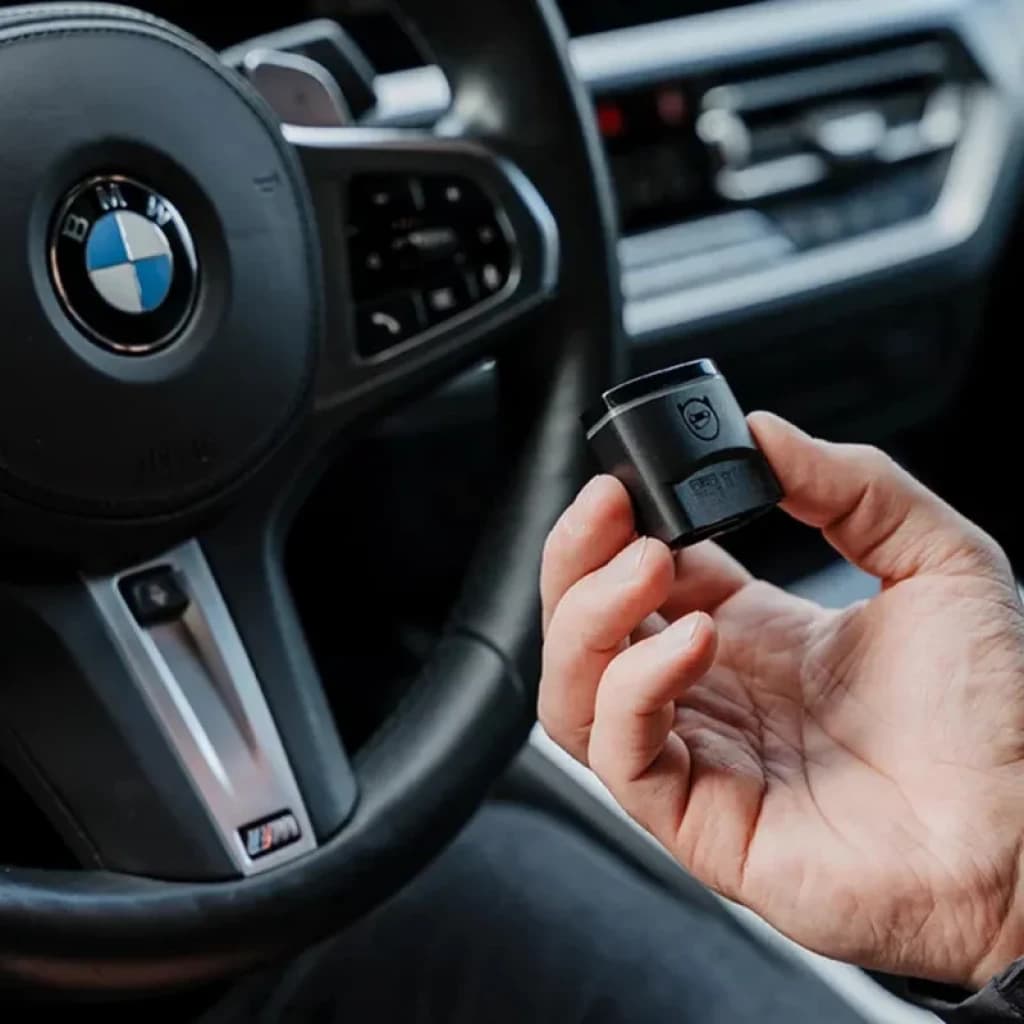 Scanner de diagnostic OBDeleven 2 Pro Pack Programmation VAG Bluetooth BLE compact, connecteur OBD noir tenu en main, design minimaliste pour voiture