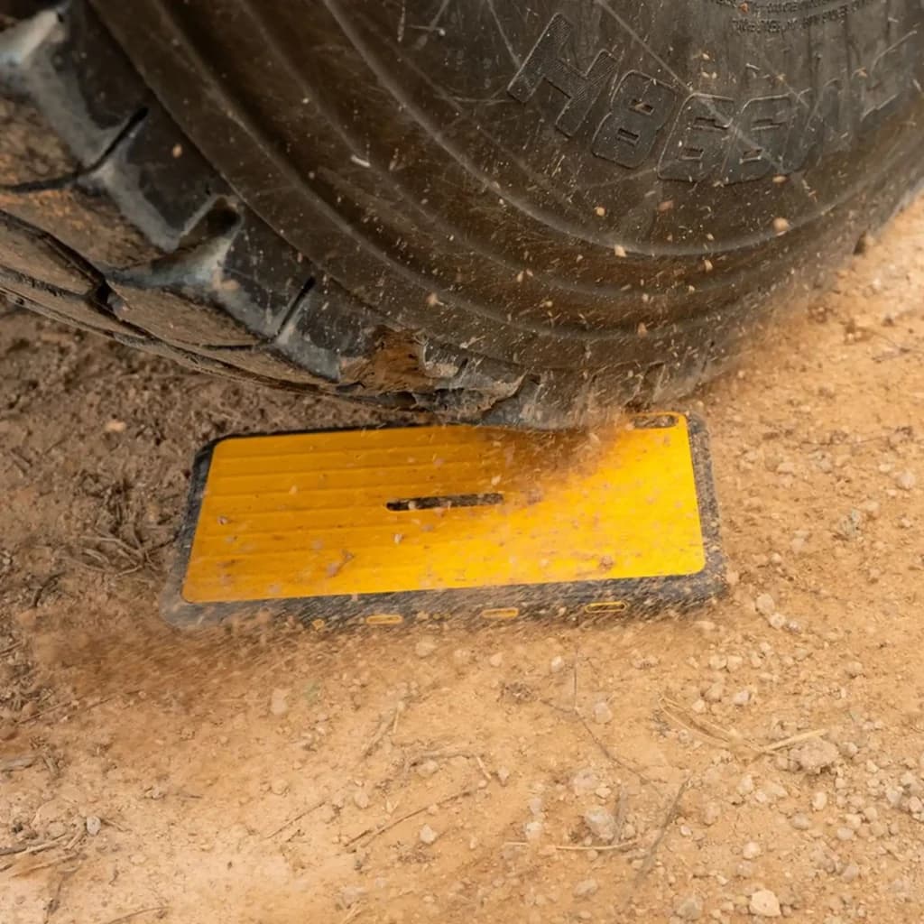 Tablette jaune robuste sous pneu, coque antichoc avec bords caoutchoutés et surface rainurée, conçue pour résister à la poussière, aux chocs et à