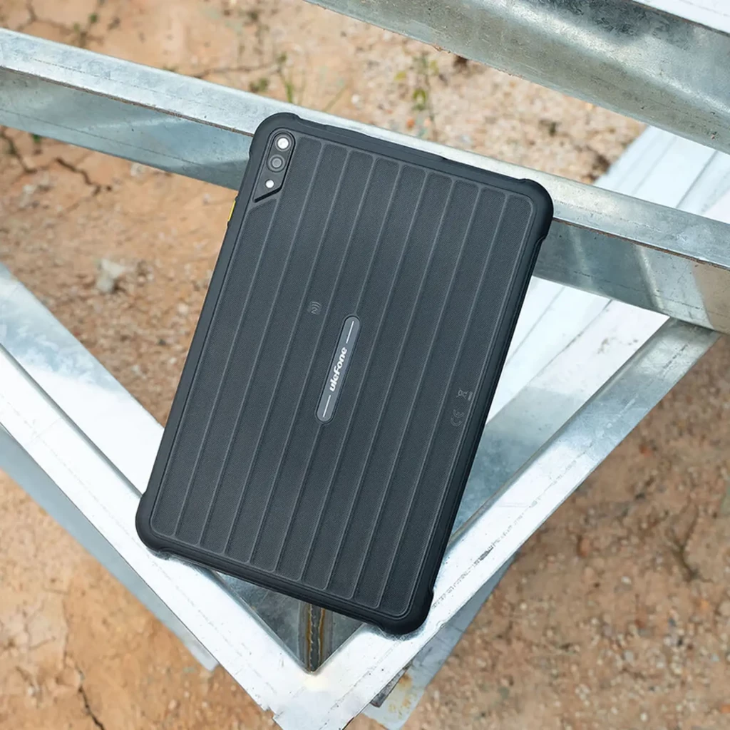 Tablette robuste noire avec coque rainurée, double caméra arrière, grand écran bord fin affichant snowboarder, ports renforcés et bords antichoc - Ítem6