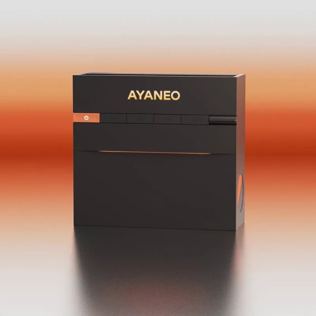 Ayaneo AM03, mini PC compacto em preto mate com o logótipo AYANEO iluminado a laranja, painel frontal com botões e ranhuras