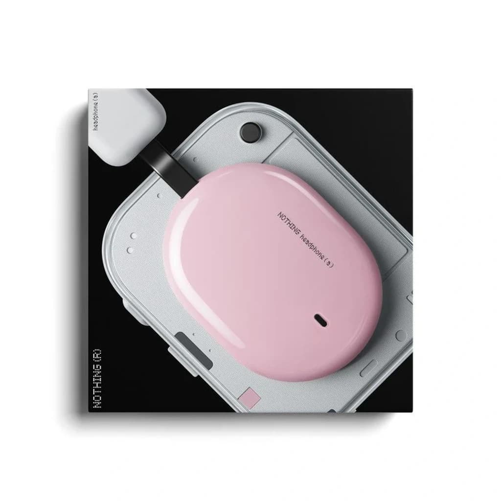 Nothing Headphone (a) Rosa – caixa oval rosa com acabamento brilhante, LED frontal e USB‑C, pousada sobre dispositivo cinza de design minimalista