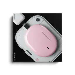 Nothing Headphone (a) Rosa – caixa oval rosa com acabamento brilhante, LED frontal e USB‑C, pousada sobre dispositivo cinza de design minimalista