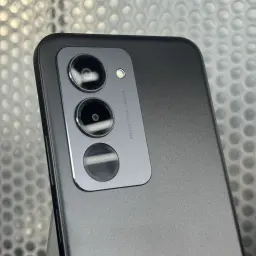 Módulo de câmera traseira tripla em preto com lentes grandes, flash LED e acabamento fosco, destaque para anel metálico e texto Innovative AI Camera