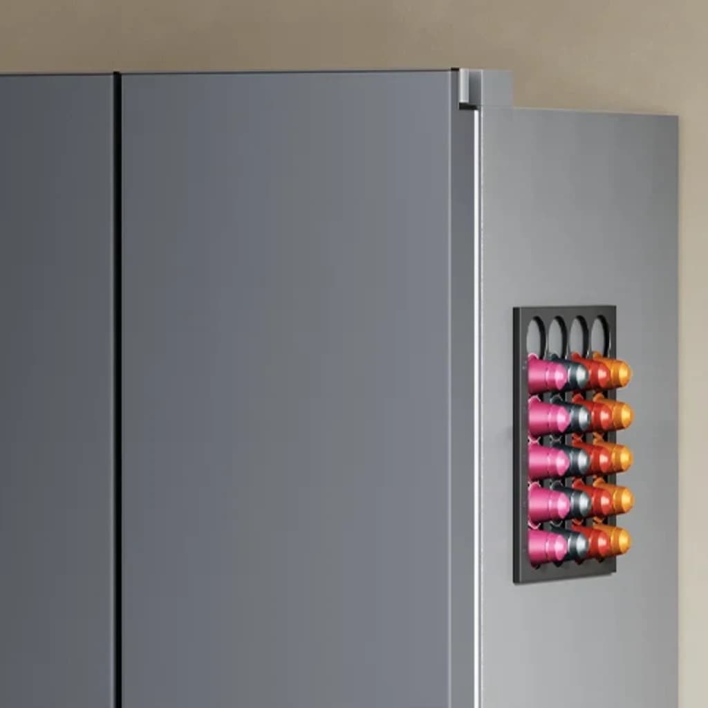 Porte grise avec support mural pour capsules Nespresso, rangées colorées roses, oranges et noires sur un rack magnétique compact