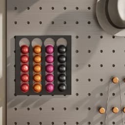 Porte‑capsules mural noir pour café, quadrillage 4 colonnes, range 20 capsules Nespresso aux couleurs orange, rose, rouge et noir, fixation sur panneau