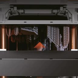 Interior da Impressora 3D de resina Creality Halot-X1 Combo 16K com peças em impressão, suportes detalhados e iluminação lateral laranja, área