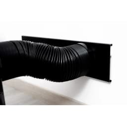 Tuyau d’évacuation noir flexible connecté à une plaque murale noire, finition mate, installation propre et discrète pour climatiseur portable S35PLUS