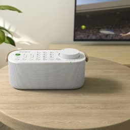 Sony SRS-LSR200 Bluetooth IPX2 Blanco con altavoz portátil, dial de volumen grande, teclas numéricas y luz LED, diseño compacto sobre mesa en sala de TV