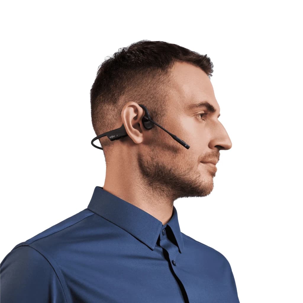 Auriculares Shokz OpenComm2 UC 2025 Upgrade Open-Ear Bluetooth USB-C 16h Negro, uso: hombre de perfil con micrófono boom