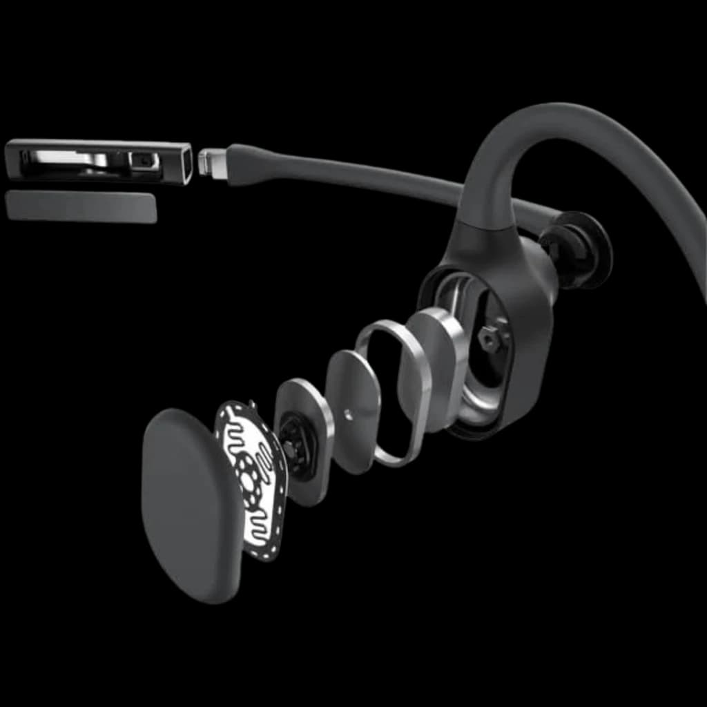 Auriculares Shokz Opencomm 2 2025 con micrófono boom y diseño de conducción ósea; vista explotada de capas internas y transductor abierto en color negro y