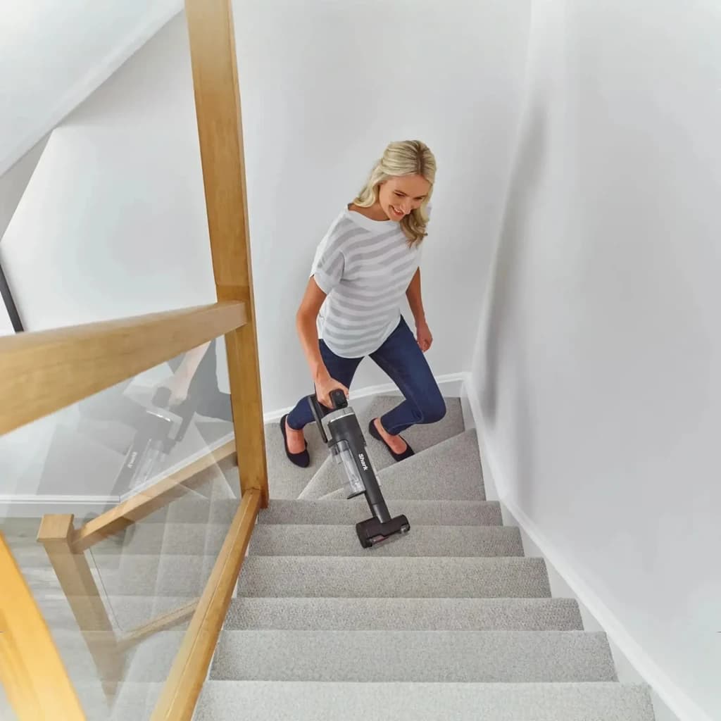 Aspiradora Escoba Shark Stratos IZ400EUT sin cable, ligera y ergonómica, usada en modo de mano para limpiar escaleras alfombradas con cepillo motorizado