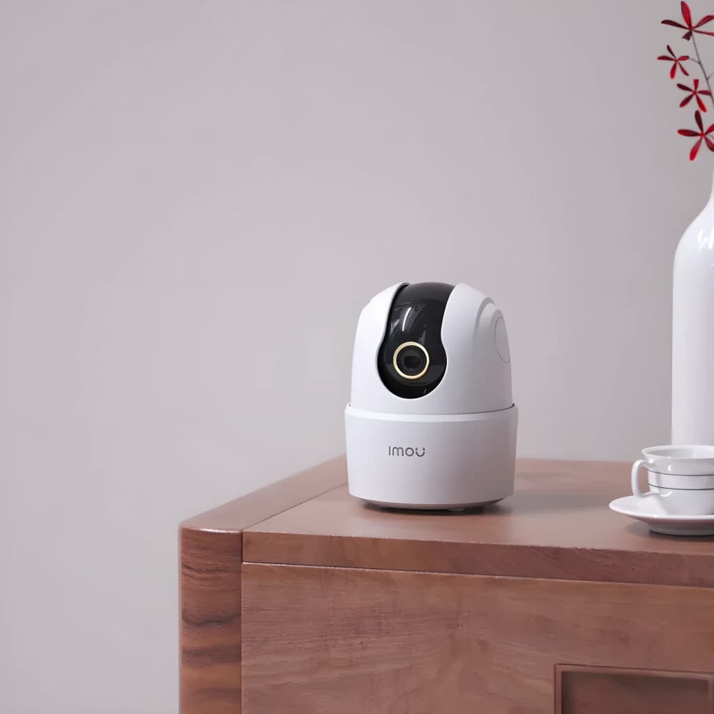 Imou Ranger 2C 3MP 256GB Blanc, vue avant en ambiance: caméra sur meuble en bois avec vase décoratif