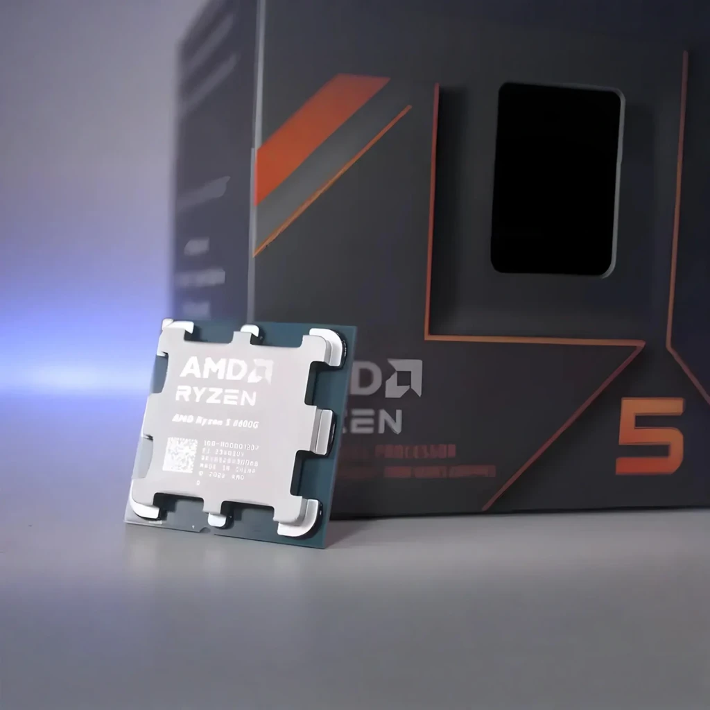 AMD Ryzen 5 8600G, vista principal: caja gris con detalles naranja junto al procesador AM5 con IHS metálico visible - Ítem4