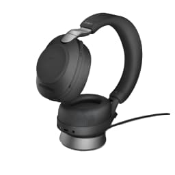 Jabra Base de escritorio Evolve2 85 USB-A negro, vista lateral: auricular negro apoyado en base de carga con cable
