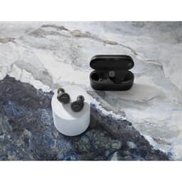 Jabra Evolve2 Buds USB-C UC negro, vista cenital: auriculares sobre peana y estuche abierto en mármol