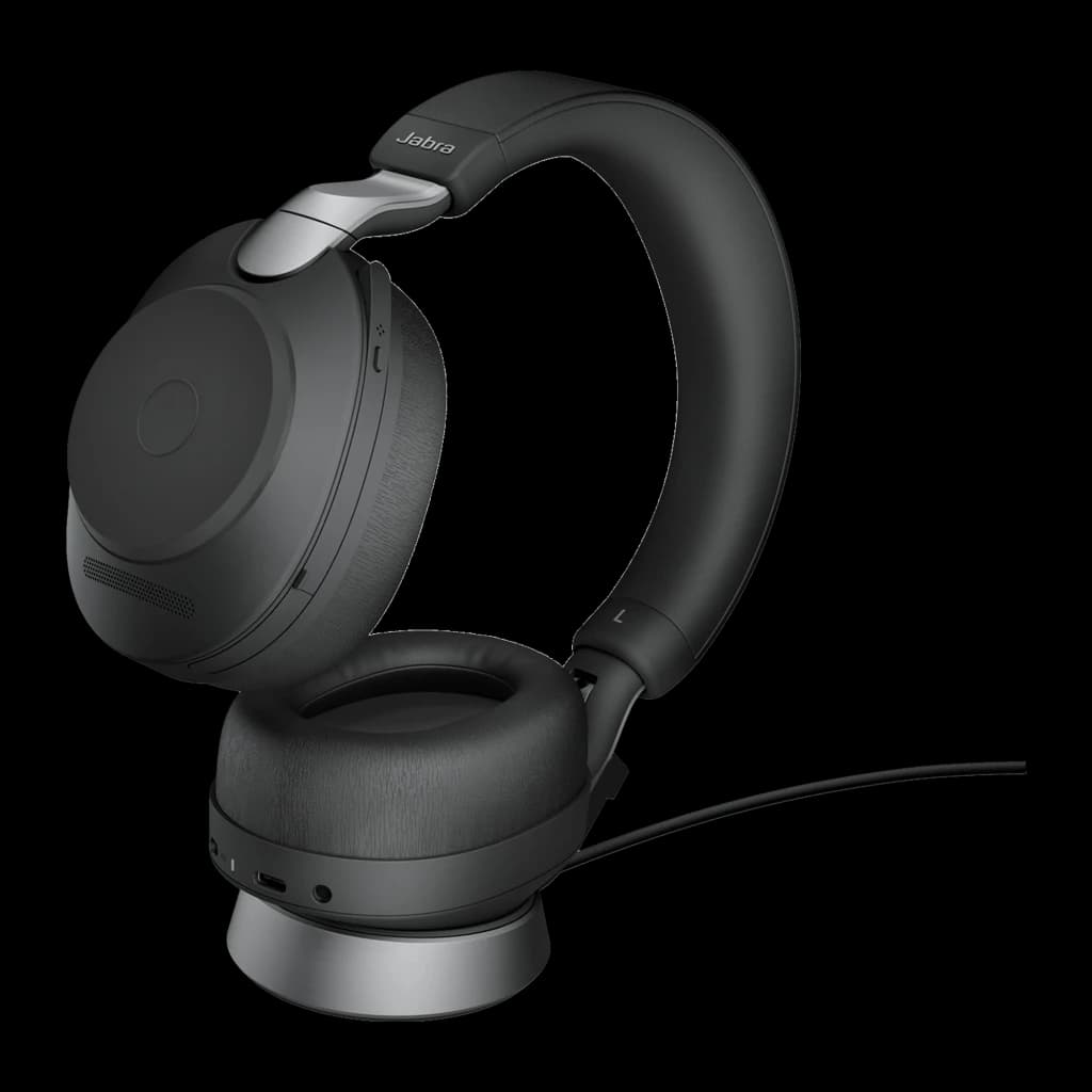 Jabra Evolve2 85 UC Stereo negro con base, vista 3/4: auriculares sobre base plateada