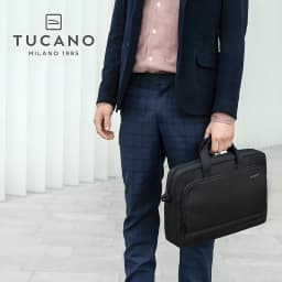 Tucano Mallette Star 15,6 pouces noir, usage: homme en costume tenant le sac par les poignées en intérieur